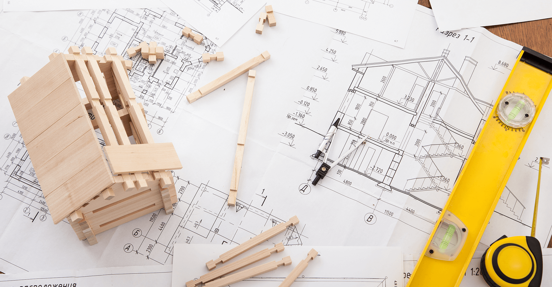 Ausgebreitete Blaupausen und Holzmodell eines Bauhauses